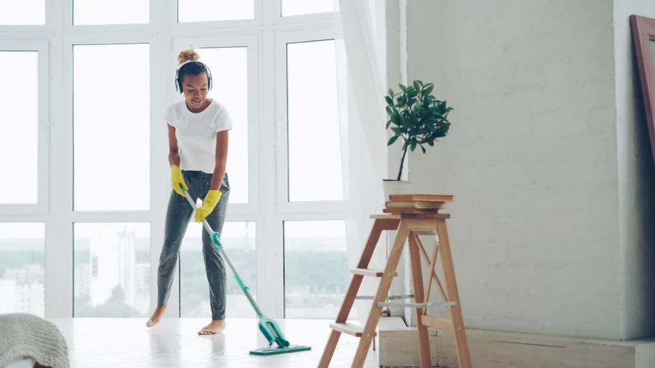 A couple is delighted as they settle into a new home, with boxes around them and simple, minimalist decor.