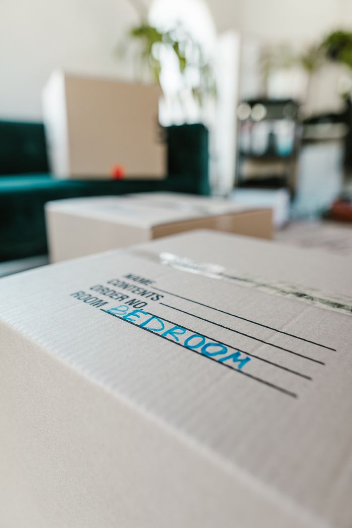 A packed cardboard box marked Bedroom sitting indoors, prepared for the move.